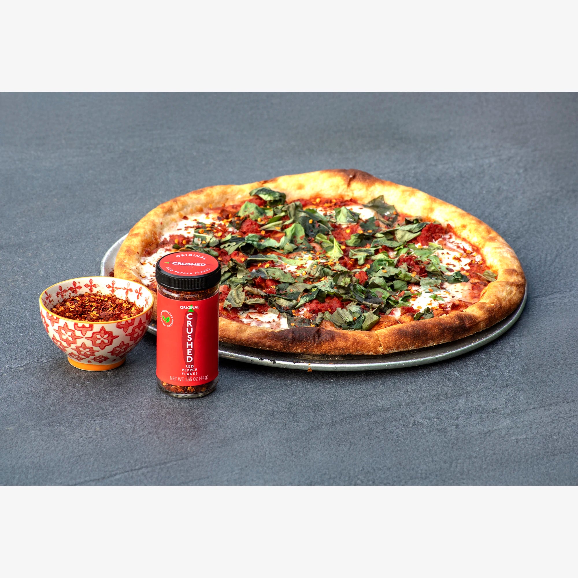 Original Crushed Red Pepper Flakes on a Margarita pizza on a slate table